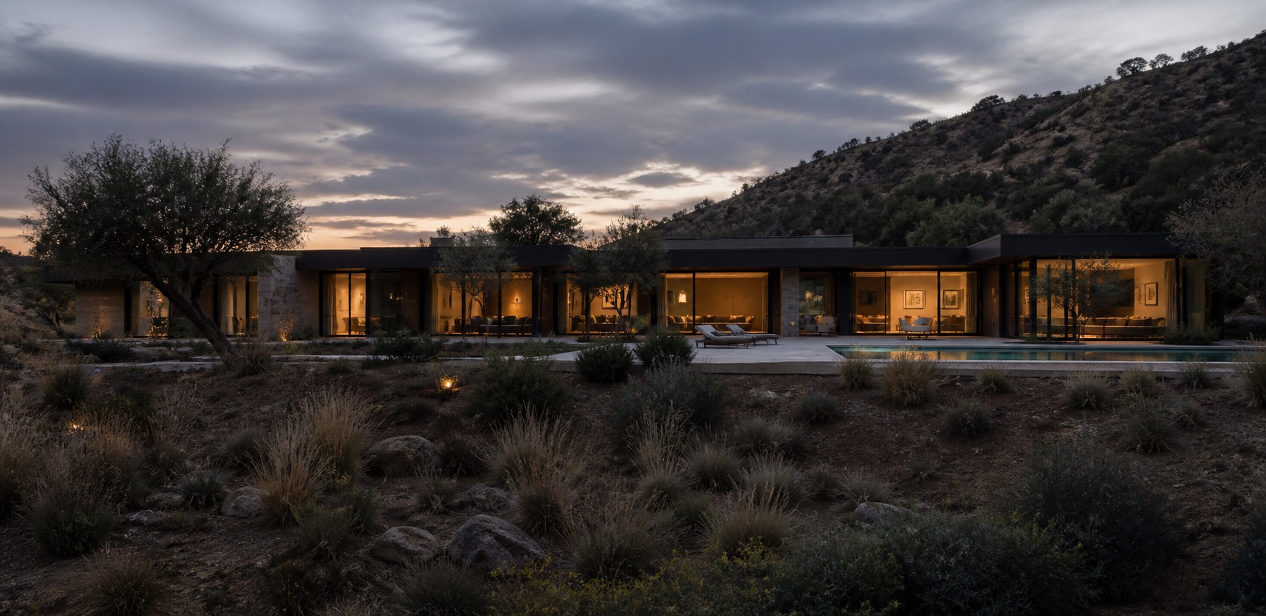 Wide Los Angeles canyon home with illuminated windows and sliding doors at twilight